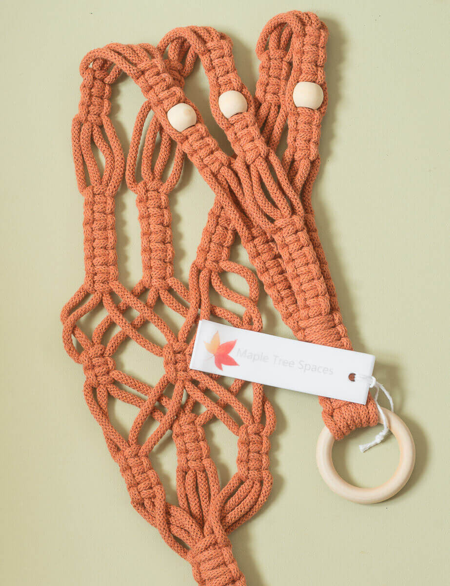 Stylish macrame plant hanger with wide cord and wooden ring, perfect for a variety of pots.