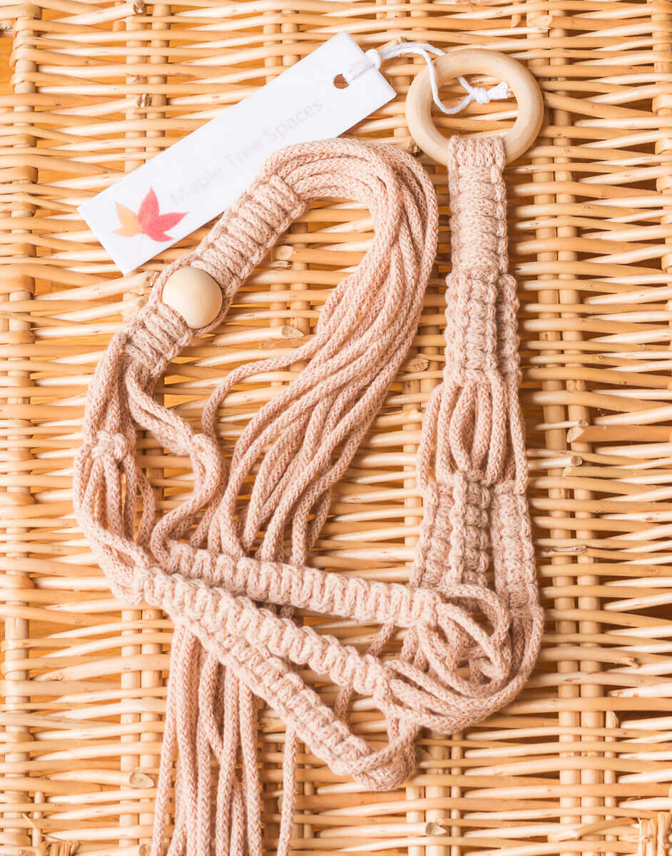 Macrame stylish small plant hanger with a 45mm ring, featuring three legs and a tail of 280mm on a wicker background.