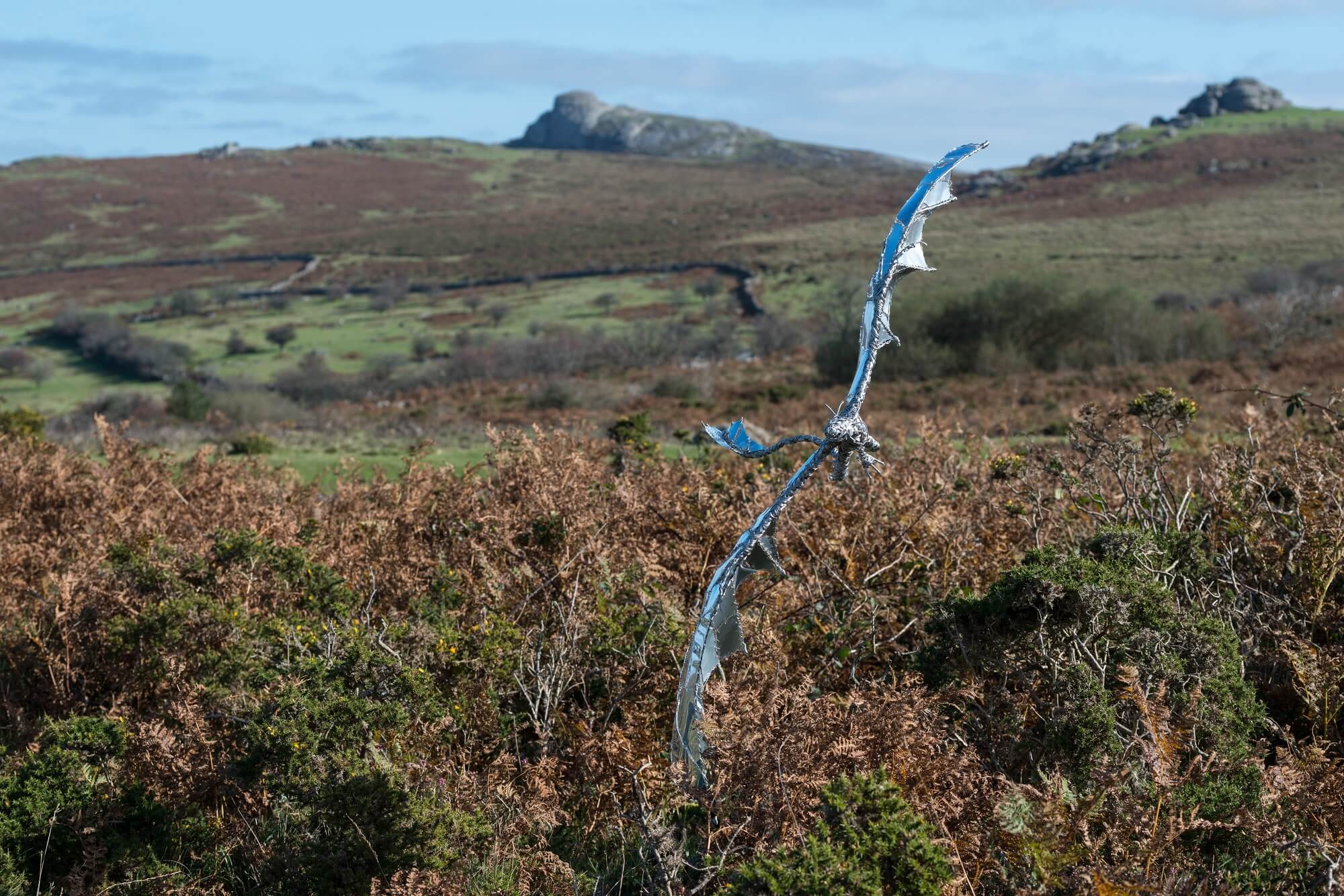Stainless steel dragon sculpture flying like a bird on Dartmoor